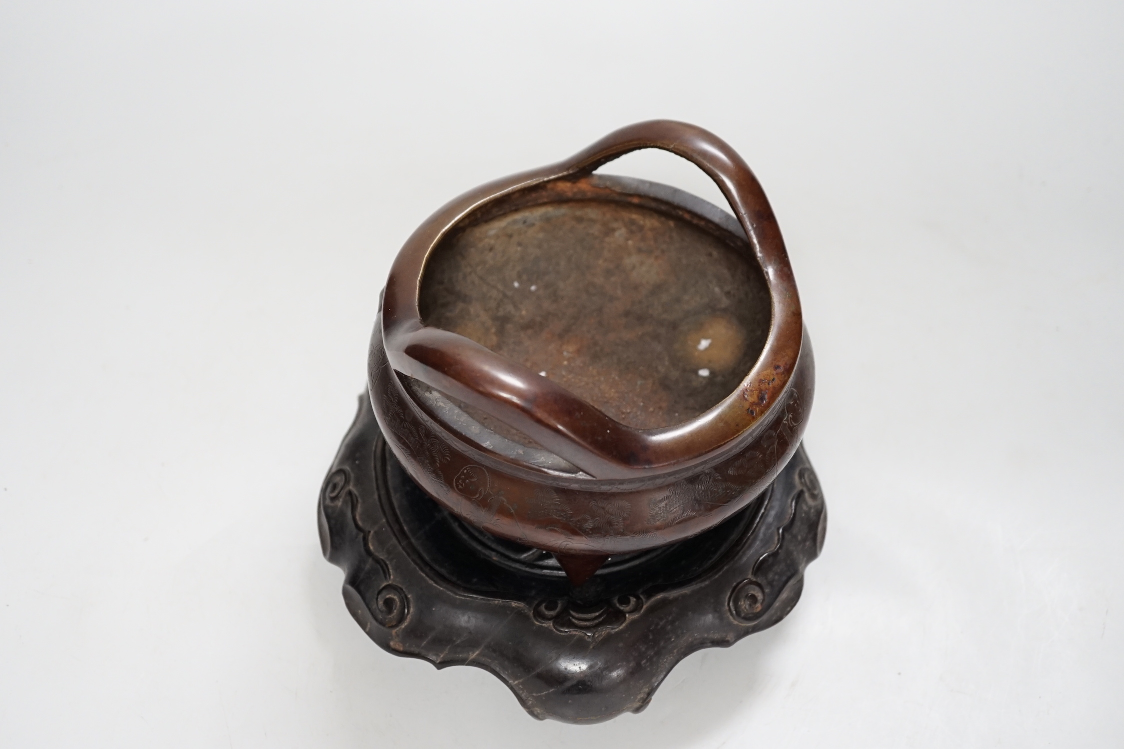A Chinese bronze censer, with engraved detail, on hardwood stand, censer 16cm diam.